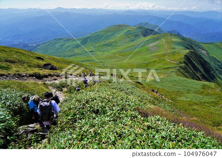 Mt. Gassan Ubagatake and a group of climbers walking along the trail Mt. Gassan Ubagatake and a group of climbers walking along the trail 104976047