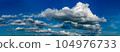 Fluffy clouds on a clear sunny day 104976733