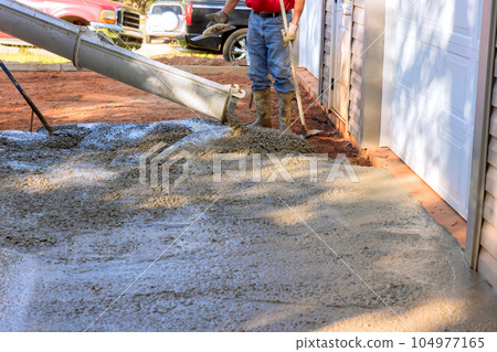 Mixer truck pouring wet cement ready mixed concrete near home that is pouring concrete for driveway Mixer truck pouring wet cement ready mixed concrete near home that is pouring concrete for driveway 104977165