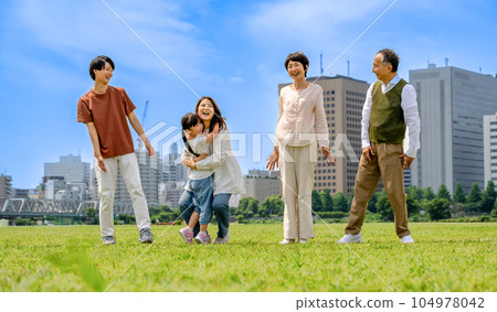Three generations of a close family walking along the riverbed 104978042