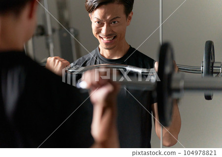 一個表情嚴肅地進行舉重訓練的男人 104978821