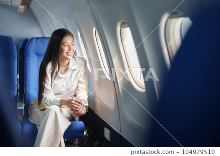 Asian attractive business woman passenger sitting on business class luxury plane while relax while travel concept. 104979510