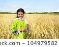 Cute pakistani girl in national dress stends in the field of golden wheat and smiling 104979582