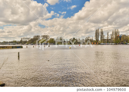 some water and trees in the middle of a large body of water with boats floating on it's surface some water and trees in the middle of a large body of water with boats floating on it's surface 104979608