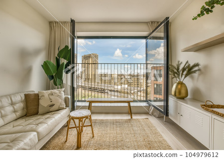 a living room with a couch, coffee table, and large window looking out onto the cityscapea 104979612