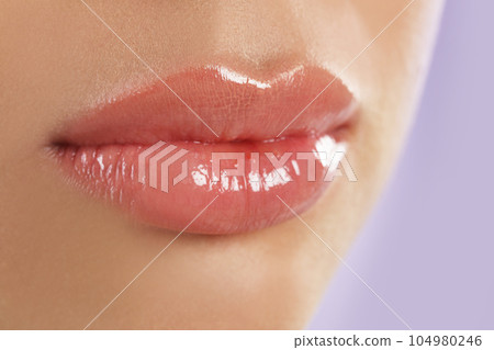 Young woman with beautiful full lips on lilac background, closeup Young woman with beautiful full lips on lilac background, closeup 104980246