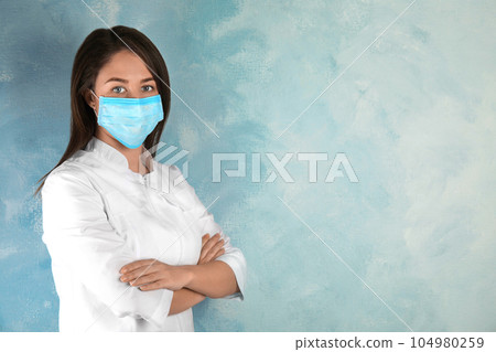 Doctor with disposable mask on face against light blue background. Space for text Doctor with disposable mask on face against light blue background. Space for text 104980259