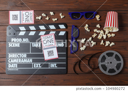 Flat lay composition with clapperboard, cinema tickets and 3d glasses on wooden table Flat lay composition with clapperboard, cinema tickets and 3d glasses on wooden table 104980272