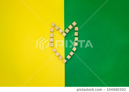 Wood cube symbols arranged in the shape of a beginner's mark with a yellow and green background 104980302