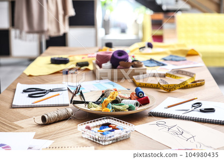 Fashion designer's workplace in studio. Creating new clothes Fashion designer's workplace in studio. Creating new clothes 104980435