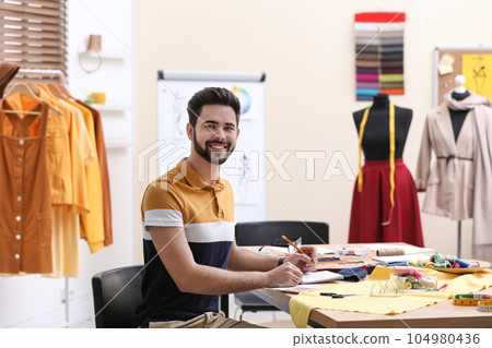 Fashion designer creating new clothes in studio 104980436