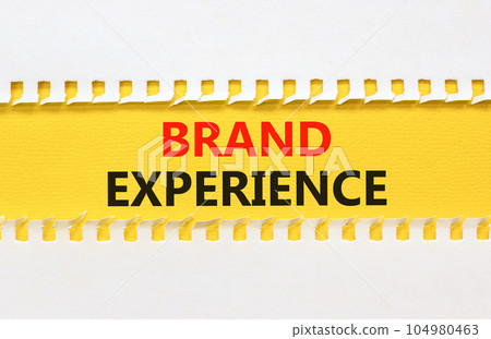 Brand experience symbol. Concept words Brand experience on yellow paper. Beautiful yellow table white background. Business branding and brand experience concept. Copy space. Brand experience symbol. Concept words Brand experience on yellow paper. Beautiful yellow table white background. Business branding and brand experience concept. Copy space. 104980463