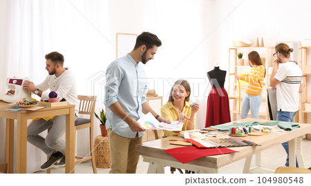 Fashion designers creating new clothes in studio Fashion designers creating new clothes in studio 104980548