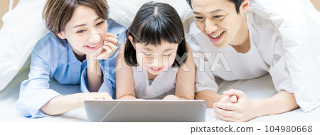 父母和孩子在床上看視頻 104980668