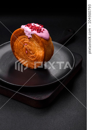 Round puff pastry croissant with raspberry filling or new york roll 104980793