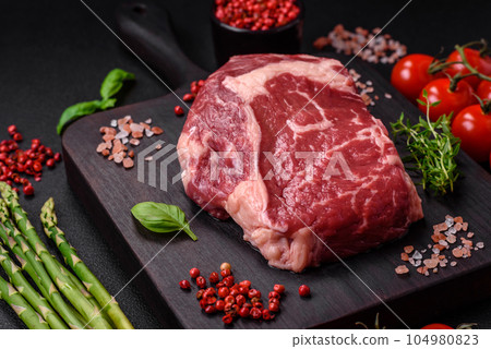 Fresh, raw beef steak with salt, spices and herbs Fresh, raw beef steak with salt, spices and herbs 104980823