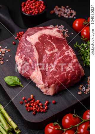 Fresh, raw beef steak with salt, spices and herbs 104980824