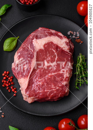 Fresh, raw beef steak with salt, spices and herbs Fresh, raw beef steak with salt, spices and herbs 104980827