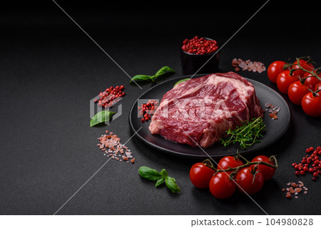 Fresh, raw beef steak with salt, spices and herbs 104980828