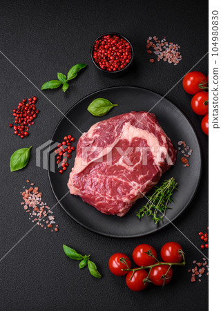 Fresh, raw beef steak with salt, spices and herbs 104980830