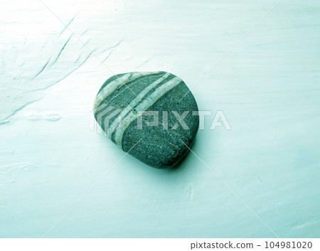 A photo of seaside pebbles with unique shapes and patterns laid out on a white background A photo of seaside pebbles with unique shapes and patterns laid out on a white background 104981020