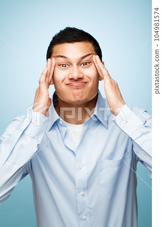 Age is taking its toll. Shot of a young man making facial expressions against a studio background. Age is taking its toll. Shot of a young man making facial expressions against a studio background. 104981574