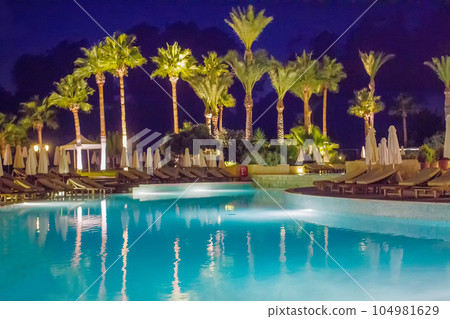 Typical pool at greek island. Sunset  Palms Blue sky 104981629