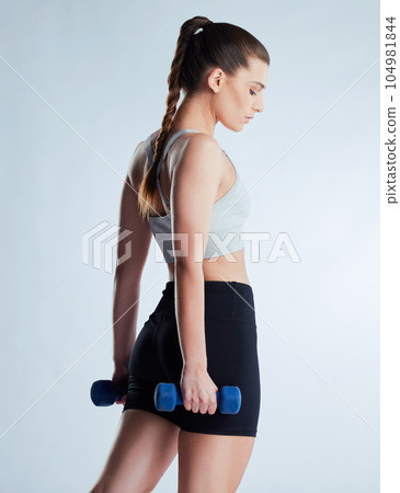 You cant afford to weight. Cropped shot of an attractive young female athlete posing in studio against a grey background. 104981844