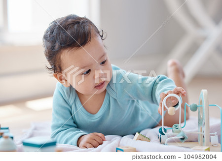 Lets give it a try. Shot of an adorable baby playing with toys. 104982004