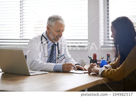 Doctor, paperwork and talking to a woman patient at hospital for a consultation or health insurance. A man listening to a happy female person in office for signature consent, support or medical help 104982517