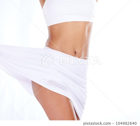 Health, weight loss and stomach, woman on diet and tummy tuck, skinny waist and isolated on white background. Fitness, healthcare and wellness, slim figure girl after liposuction or workout in studio 104982640