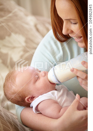 Mother, baby and feeding milk from bottle for nutrition, healthy breakfast and diet in the morning. Mom, child and feed newborn formula food for growth, development and wellness in happy home bedroom Mother, baby and feeding milk from bottle for nutrition, healthy breakfast and diet in the morning. Mom, child and feed newborn formula food for growth, development and wellness in happy home bedroom 104982845