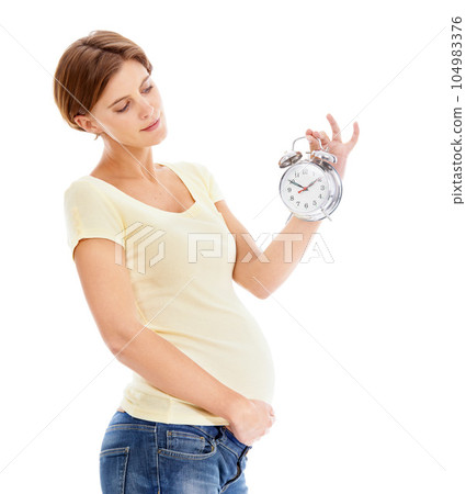 Pregnancy, alarm clock and young woman in studio holding her stomach waiting for the birth of her baby. Maternity, prenatal care and pregnant female model with time clock isolated by white background Pregnancy, alarm clock and young woman in studio holding her stomach waiting for the birth of her baby. Maternity, prenatal care and pregnant female model with time clock isolated by white background 104983376