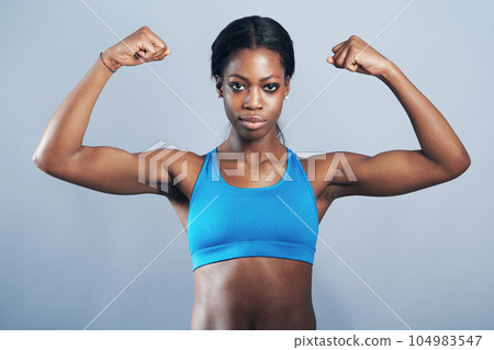 Power, fitness and portrait of black woman flexing arm muscles for exercise motivation and strong body. Health, wellness and strength, female bodybuilder sports model in arm flex on studio background 104983547