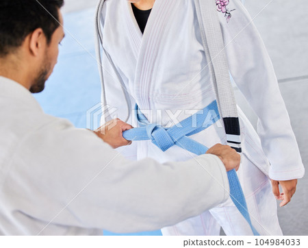 Karate, blue belt and teacher with student, fitness and taekwondo training with coach and sports. Athlete, sport development and martial arts, fighter and trainer in dojo gym practice and exercise. Karate, blue belt and teacher with student, fitness and taekwondo training with coach and sports. Athlete, sport development and martial arts, fighter and trainer in dojo gym practice and exercise. 104984033