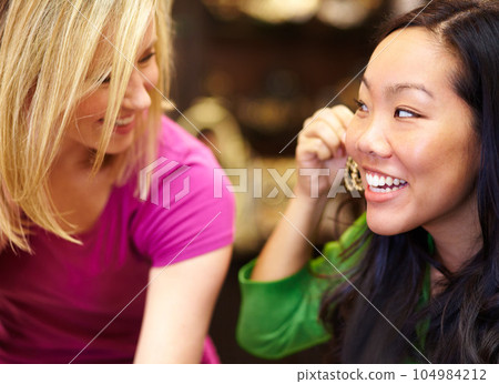 Jewelry, retail and friends shopping in a mall together for earrings or accessories with a smile. Diversity, sales or fashion with an asian woman customer and her best friend bonding in a store 104984212