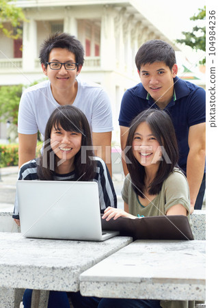 Smile, portrait and students with a laptop for education, studying and college research. Happy, Asian and men and women with a computer and notes for university work, learning and a group project Smile, portrait and students with a laptop for education, studying and college research. Happy, Asian and men and women with a computer and notes for university work, learning and a group project 104984236