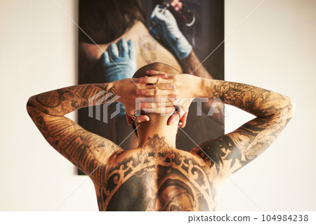 Man, tattoo and back or art with body with creativity or unique or shirtless at house. Tattoos, male person and backwards with ink with hands on head with skin for aesthetic or creative or edgy. Man, tattoo and back or art with body with creativity or unique or shirtless at house. Tattoos, male person and backwards with ink with hands on head with skin for aesthetic or creative or edgy. 104984238