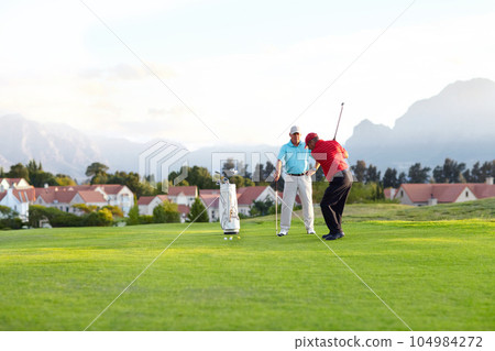 Golf course, stroke and training on the course, field or men in professional, golfer sports club and exercise on the grass. Friends, businessman or healthy game or competition on the green turf Golf course, stroke and training on the course, field or men in professional, golfer sports club and exercise on the grass. Friends, businessman or healthy game or competition on the green turf 104984272