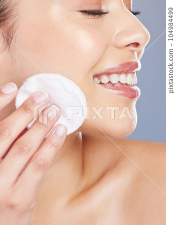 Skincare, cotton and woman woman in studio for makeup removal, toner or hydration on grey background. Smile, beauty and asian lady wellness model with facial pad for cleaning or glowing skin routine Skincare, cotton and woman woman in studio for makeup removal, toner or hydration on grey background. Smile, beauty and asian lady wellness model with facial pad for cleaning or glowing skin routine 104984499