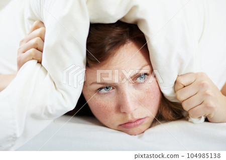 Insomnia, noise and woman with pillow on ears to block loud sound, sleep fail and tired on bed in bedroom. Stress, person and covering head with cushion for problem, tinnitus and frustrated at night. Insomnia, noise and woman with pillow on ears to block loud sound, sleep fail and tired on bed in bedroom. Stress, person and covering head with cushion for problem, tinnitus and frustrated at night. 104985138