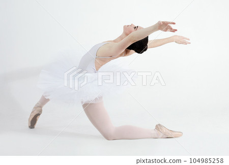 Creative, dance and ballet with a woman in studio on a white background for rehearsal or recital for theatre performance. Art, flexible and music with a young female ballerina or dancer in uniform 104985258