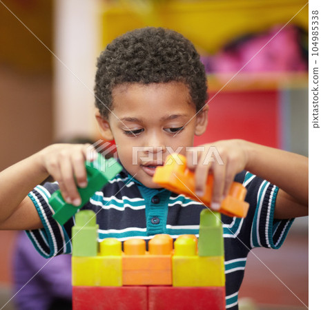 Plastic building blocks, school and boy with education, learning and happiness with safety, relax and kindergarden. Male child, kid and toddler in a classroom, fun and creative student in a creche 104985338