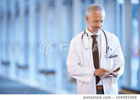 Typing, happy and a doctor with a tablet for healthcare, consulting and cardiology. Hospital, smile and a mature surgeon or medical consultant with tech for a clinic schedule, agenda or planning 104985408