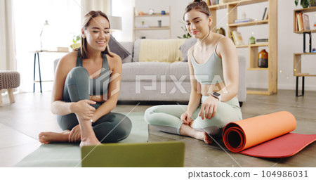 Fitness, yoga and friends in home with tablet planning workout schedule on mobile app, discussion and internet. Streaming subscription for exercise, online tutorial and women sitting in living room. 104986031