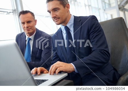 Laptop, corporate lounge and business people teamwork on finance portfolio review, stock exchange analysis or banking. Crypto, online research and professional men working on financial stocks trading 104986034