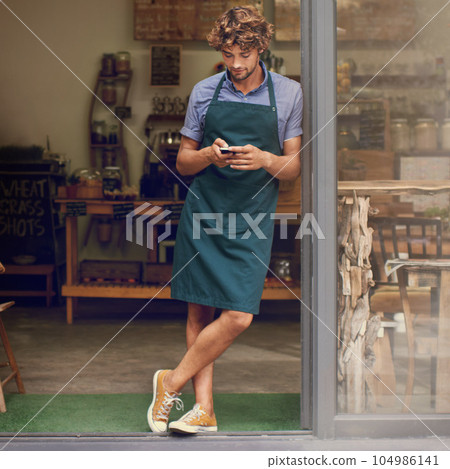 Coffee shop, typing and phone of a man as a small business owner at front door. Entrepreneur person as barista, manager or waiter in restaurant with mobile app for service, marketing or communication Coffee shop, typing and phone of a man as a small business owner at front door. Entrepreneur person as barista, manager or waiter in restaurant with mobile app for service, marketing or communication 104986141