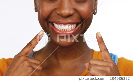 Happy isolated African American female smiling for tooth, mouth or gum and oral hygiene. Black woman, teeth and smile for dental care, whitening or healthcare against a white studio background. 104986252