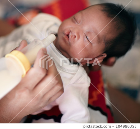 Baby with cleft lip, milk and mother feeding from bottle for nutrition, health and wellness. Formula, newborn and hand of mom feed child for development, growth or healthy diet, food or lunch at home Baby with cleft lip, milk and mother feeding from bottle for nutrition, health and wellness. Formula, newborn and hand of mom feed child for development, growth or healthy diet, food or lunch at home 104986355