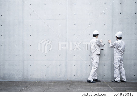 Workers in work clothes repairing and maintaining walls Workers in work clothes repairing and maintaining walls 104986813